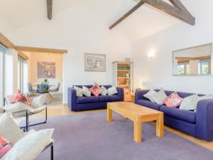 a living room with two blue couches and a table at Marigold in Shepton Mallet
