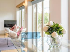 a vase of flowers sitting on a glass table at Marigold in Shepton Mallet