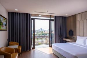a hotel room with a bed and a balcony at Mai Lakeside Hotel Ninh Binh in Kỳ Vĩ