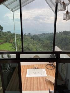 a room with a large window with a sink at Villa with Jacuzzi, Damar Ningrum 4 in Tutugan