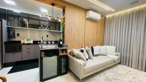 a living room with a couch and a kitchen at Studio home office Inteligente Com Alexa no Coração do Shopping in Mogi das Cruzes