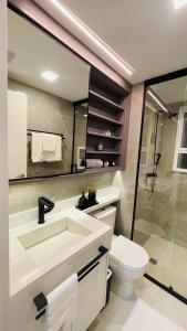 a bathroom with a sink and a toilet and a mirror at Studio home office Inteligente Com Alexa no Coração do Shopping in Mogi das Cruzes