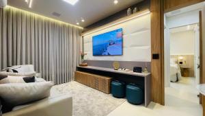 a living room with a television on a wall at Studio home office Inteligente Com Alexa no Coração do Shopping in Mogi das Cruzes