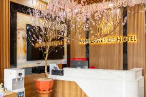 a lobby with a table and a tree in a building at Mai Lakeside Hotel Ninh Binh in Kỳ Vĩ