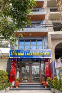 a building with a sign for a man village hotel at Mai Lakeside Hotel Ninh Binh in Kỳ Vĩ