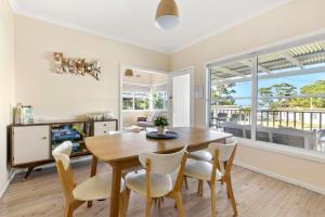 a kitchen and dining room with a wooden table and chairs at Beauts - Pet Friendly - 5 Mins Walk to Beach in Culburra Beach