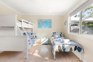 a bedroom with two bunk beds and a staircase at Beauts - Pet Friendly - 5 Mins Walk to Beach in Culburra Beach