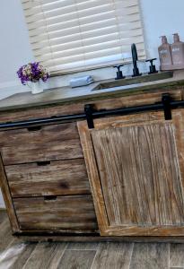 a wooden counter with a sink and a window at The Merredin Treasury Cottage in Merredin +15 photos