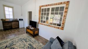 a living room with a couch and a television at The Merredin Treasury Cottage in Merredin