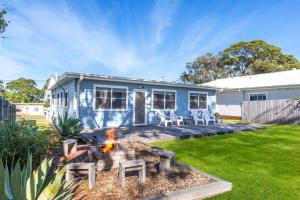 a blue tiny house with a fire pit in the yard at Beauts - Pet Friendly - 5 Mins Walk to Beach in Culburra Beach