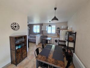 a kitchen and living room with a table and a dining room at Le Hameau des Cardenals in Salviac