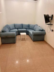 a living room with a blue couch and a table at الكرامة للشقق المفروشة in Abha +28 photos