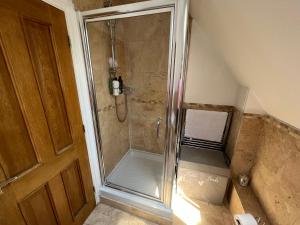 a shower with a glass door in a bathroom at Silsoe B&B Master Suite in Silsoe +62 photos