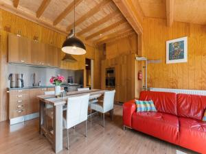 a living room with a red couch and a kitchen at Cottage in Dwingelderveld with Scenic Views in Beilen