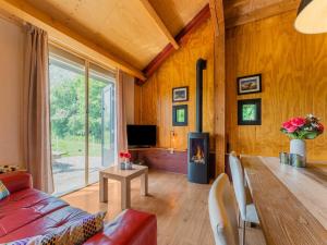 a living room with a couch and a table with a fireplace at Cottage in Dwingelderveld with Scenic Views in Beilen
