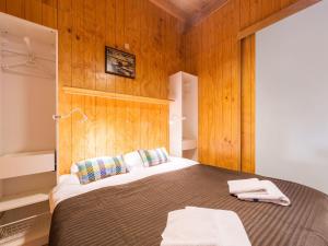 a bedroom with a large bed with wooden walls at Cottage in Dwingelderveld with Scenic Views in Beilen
