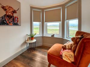 a living room with windows and a chair at Rubylea in Dumfries