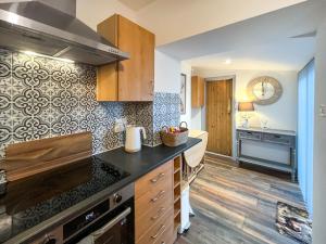 a kitchen with wooden cabinets and a counter top at Rubylea in Dumfries