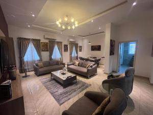 a large living room with couches and a chandelier at Lekki Waterfront Terrace shortlet with Oceanview, Attendants and private Jetty in Lagos