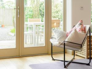 a rocking chair in front of a sliding glass door at Marigold in Shepton Mallet +15 photos