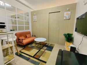 a living room with an orange chair and a table at SMDC Trees Residences Jim's Staycation in Manila