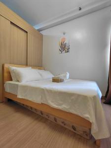 a bedroom with a large bed with white sheets at SMDC Trees Residences Jim's Staycation in Manila