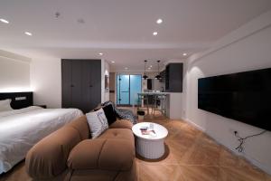 a bedroom with a bed and a couch and a tv at Funx设计师民宿 in Chengdu