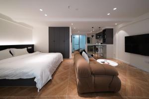 a bedroom with a bed and a couch and a tv at Funx设计师民宿 in Chengdu