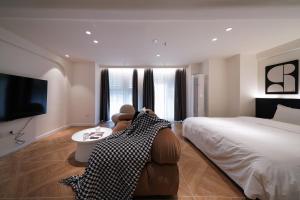 a bedroom with a bed and a chair and a tv at Funx设计师民宿 in Chengdu +5 photos