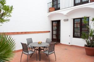 a patio with a table and chairs in front of a building at Aspasios Plaza Real Apartments in Barcelona