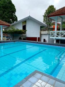 a large swimming pool in front of a house at Kencana INN in Bandungan
