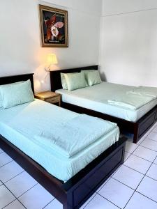 two beds sitting next to each other in a room at Kencana INN in Bandungan