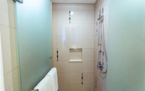 a bathroom with a shower with a glass door at New Jimbaran Hotel in Ungasan