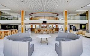 a lobby with chairs and a table in a building at New Jimbaran Hotel in Ungasan