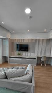 a living room with a couch and a flat screen tv at Tropical Executive Suite Flat 1001 Veiw in Manaus