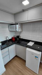 a small kitchen with a sink and a microwave at Tropical Executive Suite Flat 1001 Veiw in Manaus