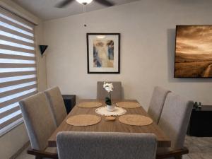 a dining room with a wooden table and chairs at Casa Pradera in Manuel F. Martínez +11 photos