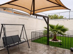 a swing and a palm tree on a patio at Casa Pradera in Manuel F. Martínez