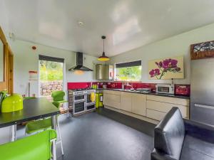a large kitchen with red countertops and green chairs at The Bunkhouse - Uk50470 in Greenhaugh