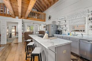 a kitchen with a large counter with stools in it at Kingfisher's Cabin 15 Minutes to Casino Hot tub Firepit in Murphy