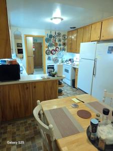 a kitchen with a table and a white refrigerator at Gary's Place in Springfield