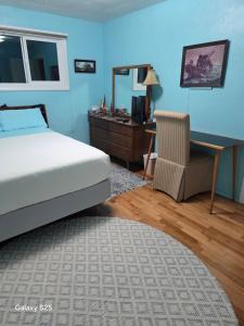 a bedroom with a bed and a desk and a chair at Gary's Place in Springfield