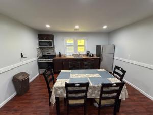 a kitchen with a table with chairs and a refrigerator at JD Apartment and House in Seaside Heights