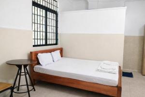 a bedroom with a bed with a table and a window at Thanh Bình Motel Bến Tre in Ben Tre