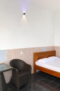 a bedroom with a bed and a chair and a table at Thanh Bình Motel Bến Tre in Ben Tre