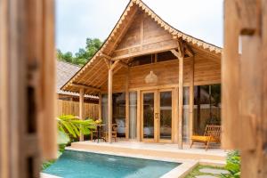a pavilion with a pool in front of a house at Taman Jati in Gili Islands