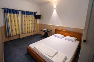 a bedroom with a bed with white sheets and a window at Thanh Bình Motel Bến Tre in Ben Tre