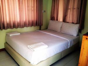 a bed with white sheets and pillows in a room at Satakanta Resort Lampang in Ban Nong Chaeng