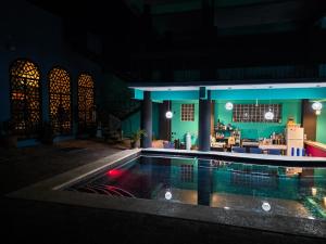 a swimming pool in a building at night at Confetti Pool Club in San Pablo Villa de Mitla
