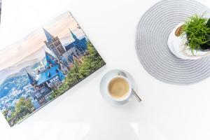 a cup of coffee next to a picture of the disney castle at elaya hotel wolfenbuettel, Trademark Collection by Wyndham in Wolfenbüttel